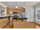 Kitchen with stainless appliances, black countertops, an island, and light wood cabinets at 2744 Laurelcherry St, Raleigh, NC 27612
