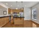 Kitchen features wood cabinets, stainless steel appliances and a center island with black countertop at 2744 Laurelcherry St, Raleigh, NC 27612