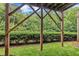 View under deck showing structural beams, lawn and privacy landscaping with a forest backdrop at 2744 Laurelcherry St, Raleigh, NC 27612