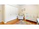 bedroom featuring a white crib, chair, and hardwood floors at 2805 Friendship Rd, Durham, NC 27705