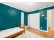 Bedroom with hardwood floors, closet space, and teal accent wall, creating a vibrant space at 2805 Friendship Rd, Durham, NC 27705