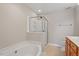 Bright bathroom featuring a jetted tub and glass enclosed shower at 2822 Pickett Rd # 132, Durham, NC 27705