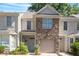 Charming townhouse featuring stone accents, a one-car garage, and well-maintained landscaping at 2822 Pickett Rd # 132, Durham, NC 27705