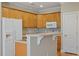 Well-lit kitchen with light wood cabinets, a breakfast bar and white appliances at 2822 Pickett Rd # 132, Durham, NC 27705