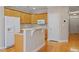 Bright kitchen with light wood cabinets, white appliances, and a breakfast bar at 2822 Pickett Rd # 132, Durham, NC 27705