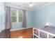 Light-filled bedroom with hardwood floors, a ceiling fan and a large window that provides ample natural light at 301 Presque Isle Ln, Chapel Hill, NC 27514