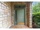 Charming front door with stone surround, brass accents, and sidelight providing a warm and inviting entrance at 301 Presque Isle Ln, Chapel Hill, NC 27514