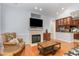 Comfortable living room showcasing hardwood floors, a cozy fireplace, and an open layout to the kitchen area at 301 Presque Isle Ln, Chapel Hill, NC 27514