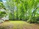 Large and private backyard surrounded by lush green trees and landscaping at 310 Heidinger Dr, Cary, NC 27511
