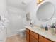 A bright bathroom with a shower-tub, vanity, round mirror, and decorated with plants and a picture at 310 Heidinger Dr, Cary, NC 27511