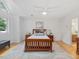 Bright bedroom featuring a wooden bed frame, neutral rug, and view of backyard from windows at 310 Heidinger Dr, Cary, NC 27511