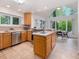 Well-lit kitchen with tile floors, wooden cabinets, stainless steel appliances, and a central island with sink at 310 Heidinger Dr, Cary, NC 27511