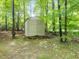 Outdoor storage shed surrounded by a lush wooded lot with mature trees and greenery at 310 Heidinger Dr, Cary, NC 27511