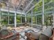 Bright sunroom featuring a glass ceiling, tiled flooring, and comfortable seating area overlooking lush greenery at 310 Heidinger Dr, Cary, NC 27511