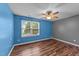 Bedroom with blue walls, wood floors, a ceiling fan, and a window at 3705 Rivermist Dr, Raleigh, NC 27610