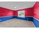 Bedroom featuring blue and red accent walls, carpet flooring, and natural light at 3705 Rivermist Dr, Raleigh, NC 27610