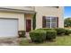 Charming home exterior with a red door, manicured bushes, light yellow siding and a single-car garage at 3705 Rivermist Dr, Raleigh, NC 27610