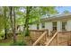 Backyard view, showcasing a wood deck, white vinyl siding, and leafy trees at 3803 Jonesville Rd, Wake Forest, NC 27587