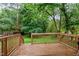 View of the deck overlooking a sprawling green backyard with lush trees and greenery at 3803 Jonesville Rd, Wake Forest, NC 27587