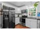 Bright kitchen with stainless steel appliances, white cabinets, and black granite counters at 3803 Jonesville Rd, Wake Forest, NC 27587
