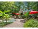 Luxurious backyard oasis featuring a spa, outdoor kitchen, lounge seating, and tropical plants at 4021 Chaumont Dr, Apex, NC 27539