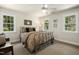 Cozy bedroom featuring a large bed, ceiling fan, and windows that provide lots of natural light at 4021 Chaumont Dr, Apex, NC 27539