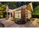 Backyard brick cabana featuring large windows, an open porch, and manicured landscaping at 4021 Chaumont Dr, Apex, NC 27539