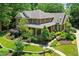 Aerial view of a grand brick home with lush landscaping, mature trees, and a well-maintained lawn at 4021 Chaumont Dr, Apex, NC 27539