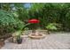 Outdoor fire pit area with a stone surround, bamboo backdrop, and a surrounding brick patio at 4021 Chaumont Dr, Apex, NC 27539