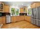 Well-lit kitchen with stainless steel appliances, wood cabinets, and tile backsplash at 4021 Chaumont Dr, Apex, NC 27539