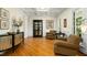 Sun-drenched living room featuring hardwood floors, decorative molding, and two comfortable armchairs at 4021 Chaumont Dr, Apex, NC 27539