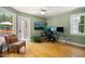 Bright home office with hardwood floors, a ceiling fan, and a door leading to a sunny outdoor area at 4021 Chaumont Dr, Apex, NC 27539