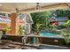 Outdoor kitchen and pool area with a covered patio, lush landscaping, and water features at 4021 Chaumont Dr, Apex, NC 27539