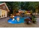 Inviting backyard pool with beautiful stonework, landscaping, waterfalls, and fire features at 4021 Chaumont Dr, Apex, NC 27539
