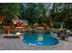 Beautiful backyard featuring a freeform pool with waterfalls, a cabana, and fire features for ambiance at 4021 Chaumont Dr, Apex, NC 27539