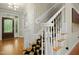 Inviting foyer with a staircase featuring a black and tan checkerboard carpet and a white banister at 4021 Chaumont Dr, Apex, NC 27539