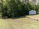 Expansive backyard featuring a playset, and a detached garage surrounded by mature trees at 4132 Battle Field Dr, Garner, NC 27529