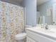 Well-lit bathroom featuring floral shower curtain, sink, and mirror at 4132 Battle Field Dr, Garner, NC 27529