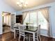 Cozy dining area with a dark wood table, white chairs, chandelier, and natural light at 4132 Battle Field Dr, Garner, NC 27529