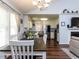 Open dining area with a dark wood table, white chairs, and a partial view into the white kitchen at 4132 Battle Field Dr, Garner, NC 27529