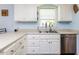 Bright kitchen features white cabinets, stainless steel appliances, and a double basin sink with window view at 4132 Battle Field Dr, Garner, NC 27529