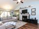 Open-concept living room with a fireplace, TV, hardwood floors, and a glimpse into the kitchen and dining area at 4132 Battle Field Dr, Garner, NC 27529