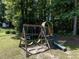 Wooden playground with swings, slide, and trampoline in a wooded backyard setting at 4132 Battle Field Dr, Garner, NC 27529