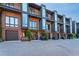 Exterior view of modern townhomes with brick facade, black accents, and individual garage entrances at 414 Chavis Way, Raleigh, NC 27601
