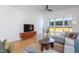 Bright living room with hardwood floors, a large window, comfortable seating, and a modern media console at 414 Chavis Way, Raleigh, NC 27601