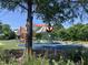 A play structure in a park surrounded by lush greenery provides children with a vibrant and engaging recreational space at 414 Chavis Way, Raleigh, NC 27601