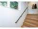 Modern staircase with wooden steps, black handrail, and natural light from a window at 414 Chavis Way, Raleigh, NC 27601