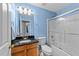 Bathroom with blue walls, black granite vanity, toilet, and shower with glass door at 4221 Ivy Hill Rd, Raleigh, NC 27616