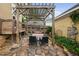 Charming stone patio with pergola, outdoor seating, and lush garden, perfect for relaxation at 4409 All Points View Way, Raleigh, NC 27614