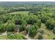 Expansive aerial view of a home nestled among lush green trees and a grassy field at 4508 Alice Dr, Oxford, NC 27565